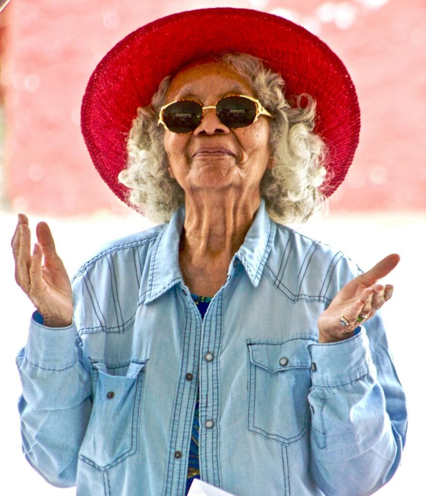 older woman wearing red hat with her arms up, enjoying her retirement on tfsa and retirement savings