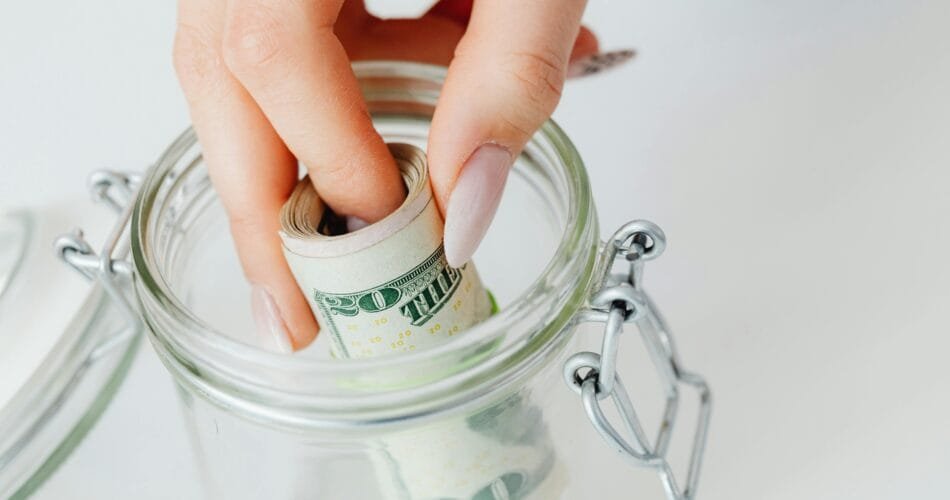 Woman Saving Money in Glass Jar for Emergency Fund