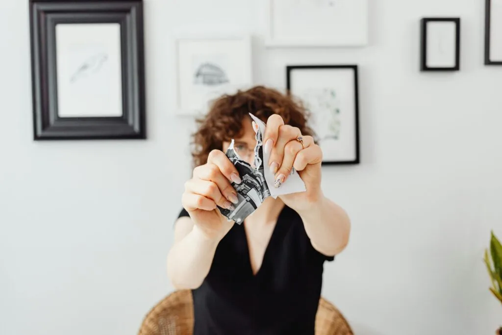 Woman tearing up her past financial mistake to reduce financial shame