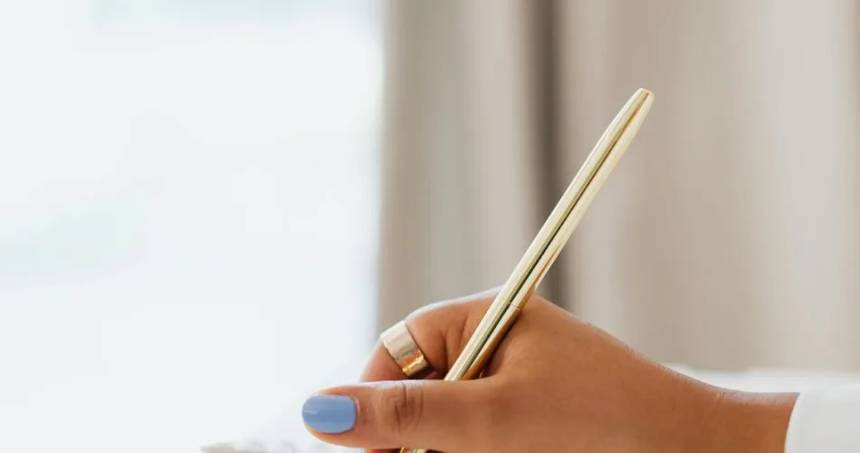 Woman setting goals in her notebook to overcome financial shame