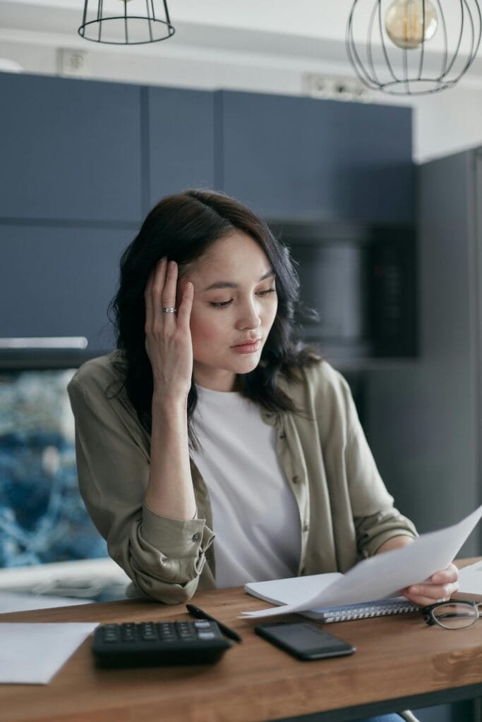 Woman looking at bill stressed over money fears.
